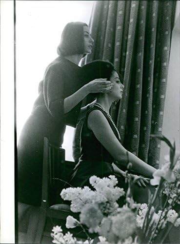 תצלום וינטג 'של פייר אנג'לי בחדר ההלבשה שלה עוסק בראשו.